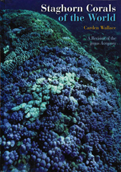 The cover image of Staghorn Corals of the World, featuring a rounded mound of earth covered by blue and pink tinted coral.