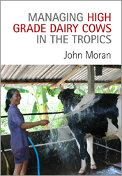The cover features a smiling south east asian woman hosing a large black and white cow in a shed with tropical trees in the background.