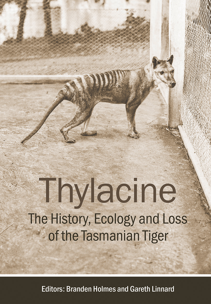 Cover of 'Thylacine' featuring a historical photo of a Tasmanian tiger within an enclosure.